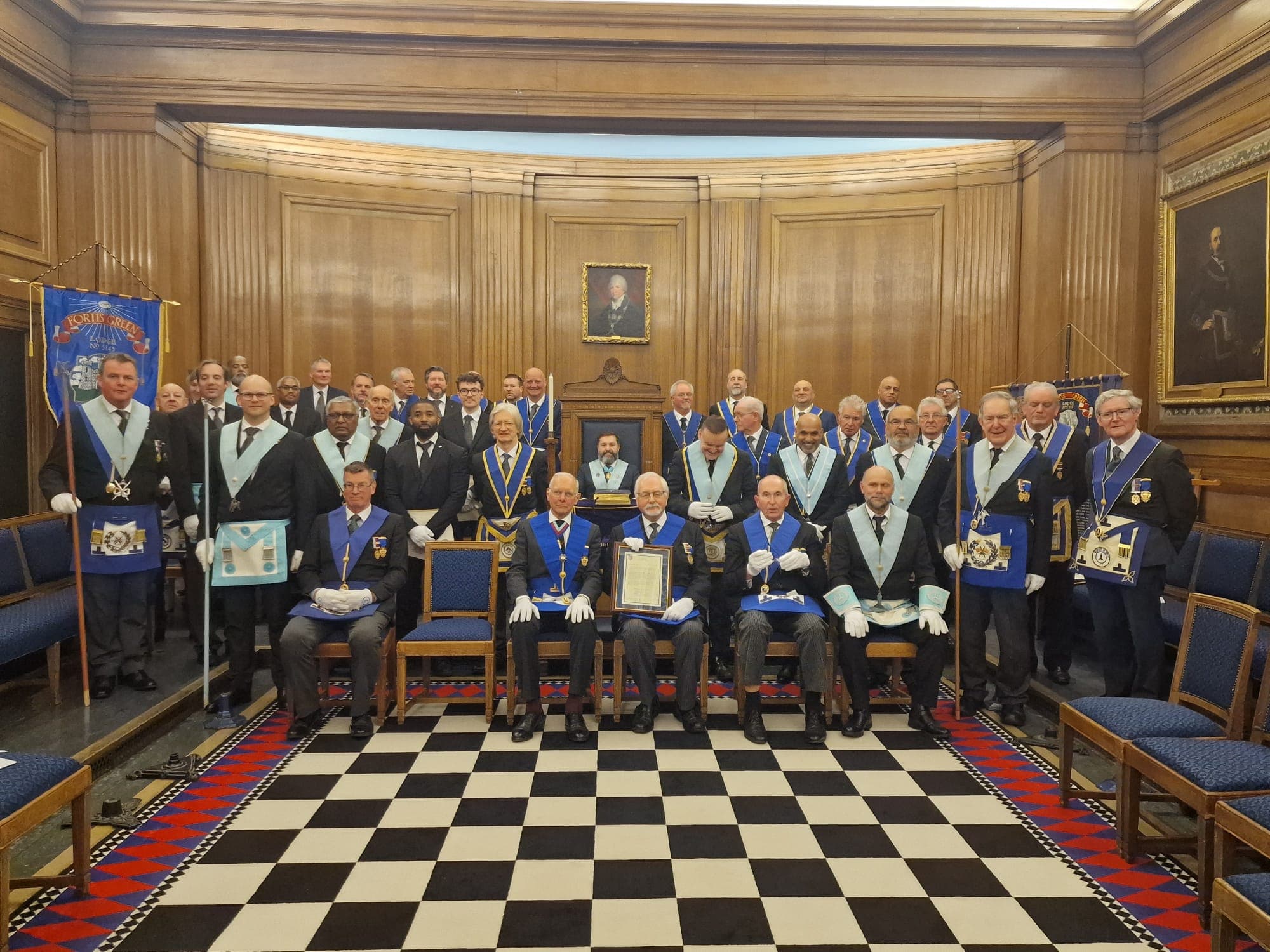 Fortis Green Lodge members in regalia on the checkered floor
